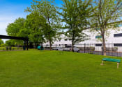 Thumbnail 9 of 17 - a park with green grass and trees in front of a building