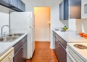 Thumbnail 1 of 13 - A kitchen with a white fridge and a white sink.