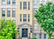 Thumbnail 11 of 13 - A large building with a green tree in front.
