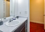 Thumbnail 7 of 13 - A bathroom with a white sink and a mirror above it.