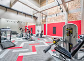 Thumbnail 10 of 13 - A gym with a variety of exercise equipment including treadmills, stationary bikes, and weight machines.