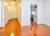 Thumbnail 4 of 13 - A long hallway with a kitchen at the end.