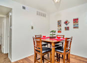 Thumbnail 4 of 14 - A dining room with a table set for two.