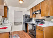 Thumbnail 3 of 14 - A kitchen with a black refrigerator, stove, and oven.