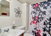 Thumbnail 6 of 14 - A white sink with a flower on the wall and a shower curtain with a flower design.