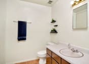 Thumbnail 8 of 14 - A white bathroom with a toilet, sink, and mirror.