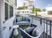 Thumbnail 23 of 45 - a patio with two couches and a table on a balcony