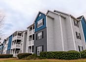Thumbnail 15 of 31 - a group of apartment buildings with blue and gray siding