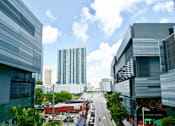 Thumbnail 69 of 71 - A city street with buildings on either side and a clear blue sky above.