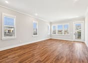 Thumbnail 13 of 38 - A room with wooden floors and white walls.