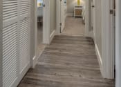 Thumbnail 12 of 20 - a long hallway with white doors and a bedroom in the end