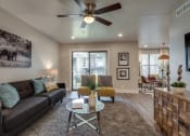 Thumbnail 3 of 20 - a living room with a couch and a ceiling fan