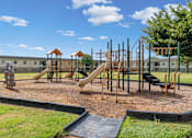 Thumbnail 13 of 23 - A playground with a slide, swings, and a climbing frame.