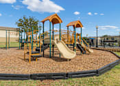 Thumbnail 12 of 23 - A playground with a yellow slide and two orange towers.