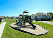 Thumbnail 13 of 15 - a playground with slides in a neighborhood with houses