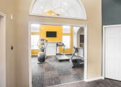 Thumbnail 3 of 22 - a gym with exercise machines and a yellow wall and a white door