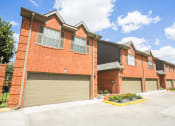 Thumbnail 22 of 22 - an empty parking lot in front of a brick building with garages