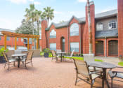 Thumbnail 8 of 22 - a patio with tables and chairs outside of a brick building