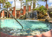 Thumbnail 7 of 22 - a pool with a waterfall in front of a house