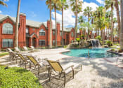Thumbnail 6 of 22 - a pool with chairs and a waterfall in front of a building