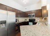 Thumbnail 12 of 22 - a kitchen with stainless steel appliances and granite counter tops