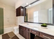Thumbnail 17 of 22 - a bathroom with a sink and a toilet and a mirror