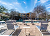 Thumbnail 31 of 36 - a pool with lounge chairs and a building in the background