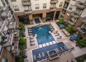 Thumbnail 11 of 30 - an aerial view of an apartment building with a large pool