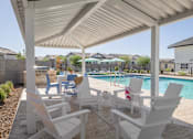 Thumbnail 21 of 21 - A white patio with chairs and a pool.