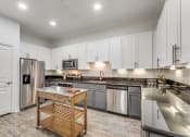 Thumbnail 1 of 21 - a large kitchen with stainless steel appliances and white cabinets