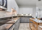 Thumbnail 3 of 21 - a large kitchen with stainless steel counter tops and white cabinets