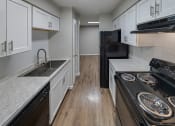 Thumbnail 2 of 19 - a kitchen with white cabinets and stainless steel appliances and a black refrigerator