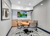 Thumbnail 26 of 33 - a conference room with a table and chairs and a tv on the wall
