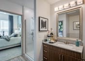 Thumbnail 9 of 32 - A bathroom with a large mirror and a sink.