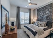 Thumbnail 6 of 32 - A bedroom with a large bed and a ceiling fan.
