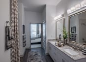 Thumbnail 13 of 32 - A bathroom with a large mirror and a sink.