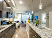 Thumbnail 2 of 25 - a kitchen and living room with a counter top