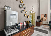 Thumbnail 13 of 21 - A modern kitchen with a coffee machine and a vase on the counter.