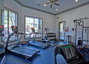 Thumbnail 24 of 28 - A gym with treadmills, elliptical machines, and other exercise equipment.