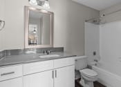 Thumbnail 7 of 29 - a bathroom with white cabinets and a sink and a toilet