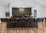 Thumbnail 15 of 24 - a kitchen with a bar and chairs in front of a wood floor
