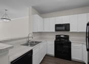 Thumbnail 4 of 26 - a kitchen with white cabinets and black appliances