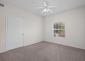Thumbnail 7 of 26 - an empty bedroom with a ceiling fan and a window