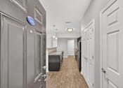 Thumbnail 22 of 31 - A hallway with a blue sign on the wall and white doors on the right.