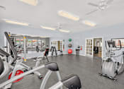 Thumbnail 11 of 20 - A gym with a variety of exercise equipment including treadmills, stationary bikes, and weight machines.