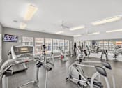 Thumbnail 10 of 20 - A gym with treadmills, exercise bikes, and other equipment.
