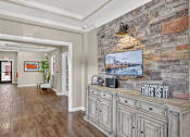 Thumbnail 9 of 20 - A hallway with a stone wall and a TV mounted on it.
