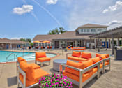 Thumbnail 2 of 20 - A poolside area with orange chairs and a clear blue sky.
