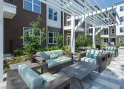Thumbnail 30 of 34 - a patio with tables and chairs under a white pergola
