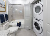 Thumbnail 8 of 34 - a bathroom with a washer and dryer in it and a toilet and tub